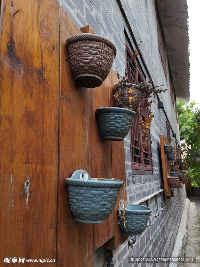 古樸墻面懸掛的多彩陶瓷花盆