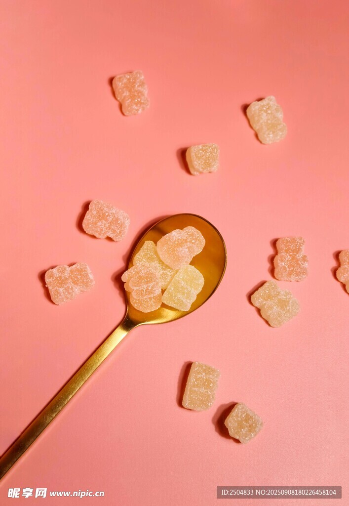 粉色背景上的勺子與糖果