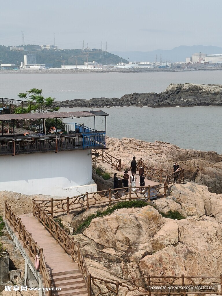 海邊棧道旁的巖石與游人