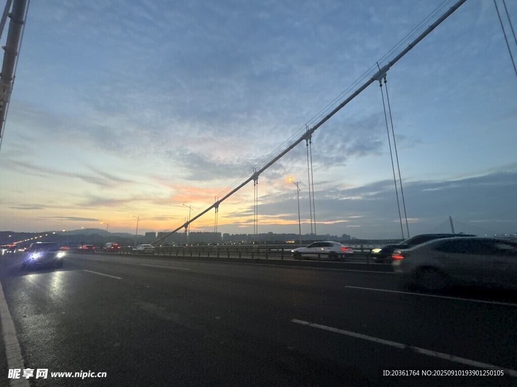 黃昏下橋上行駛的車輛