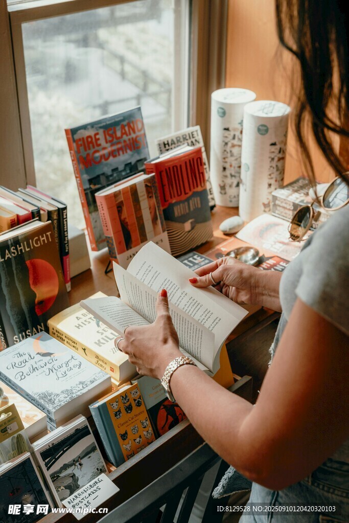 女孩于書堆中專注閱讀