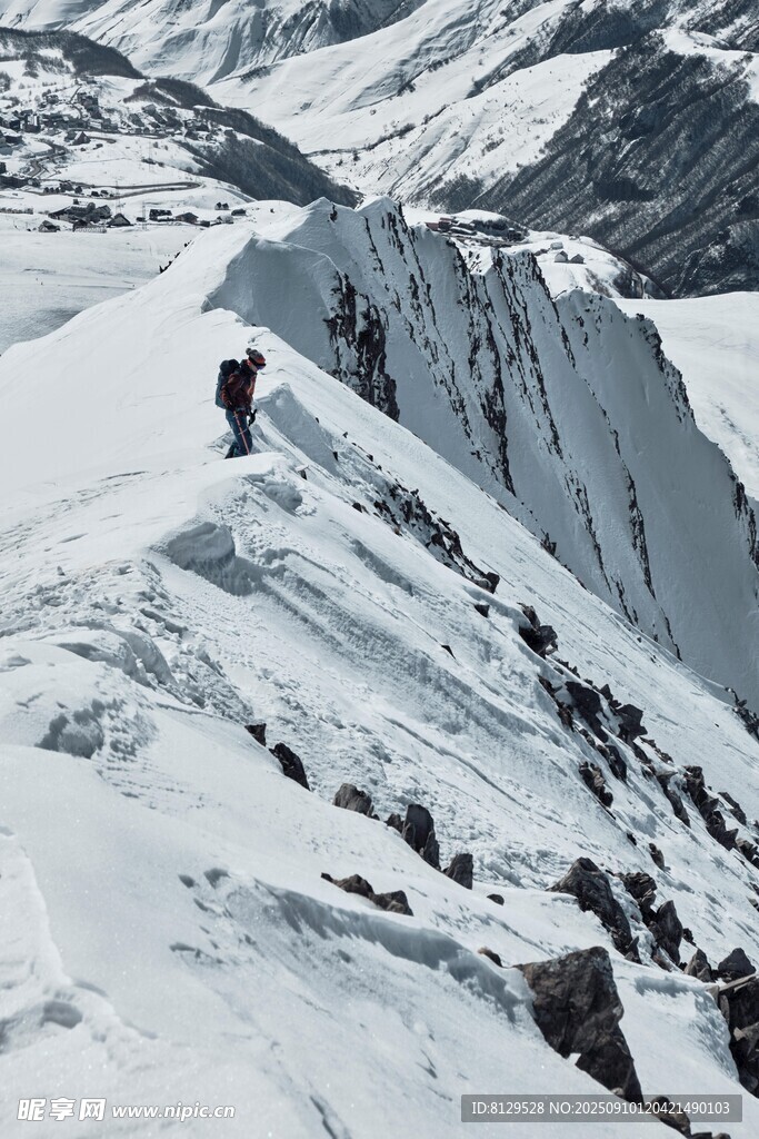 攀登者在雪覆山峰上前行