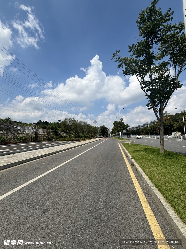 寬闊公路旁綠樹(shù)藍(lán)天白云