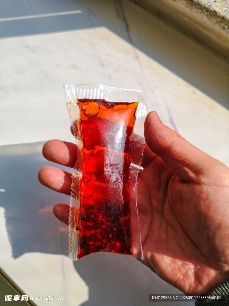 手持紅色顆粒包裝飲品