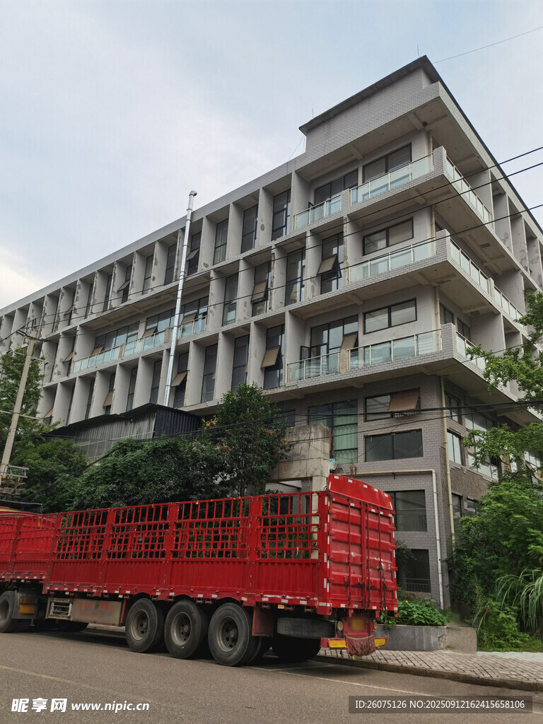 紅色貨車停于現(xiàn)代建筑旁