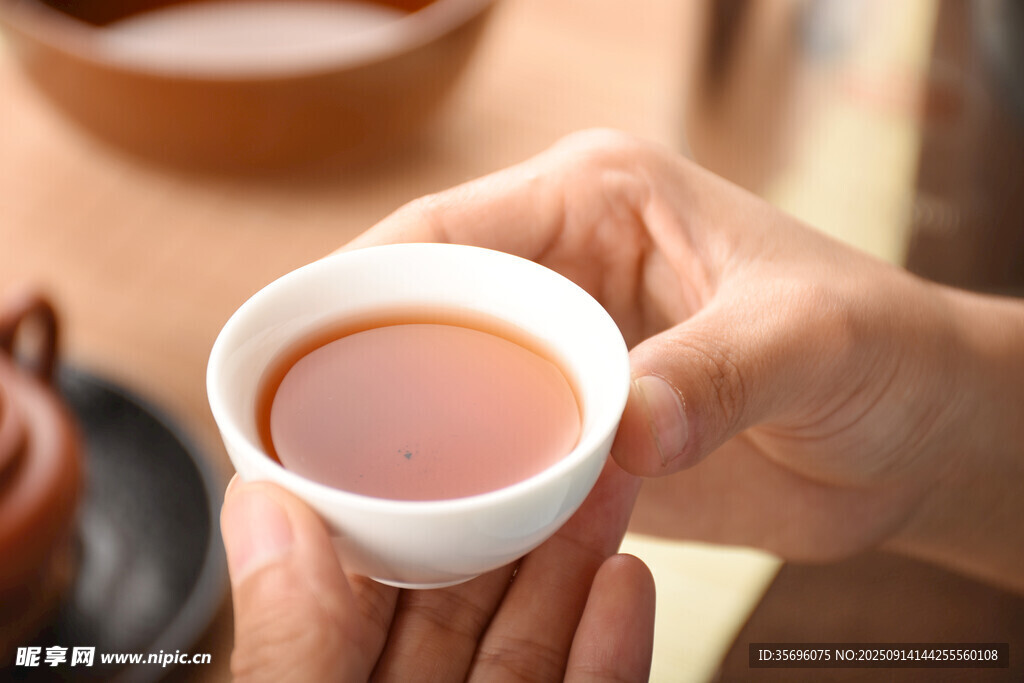 雙手捧杯品香茗