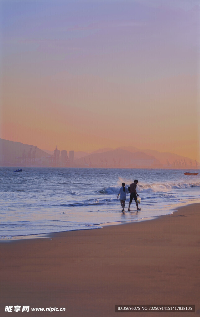 黃昏海灘上的漫步身影