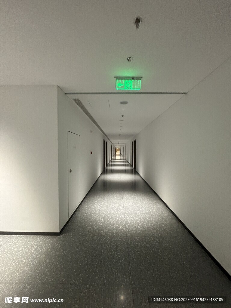 空曠走廊盡頭的綠色指示燈
