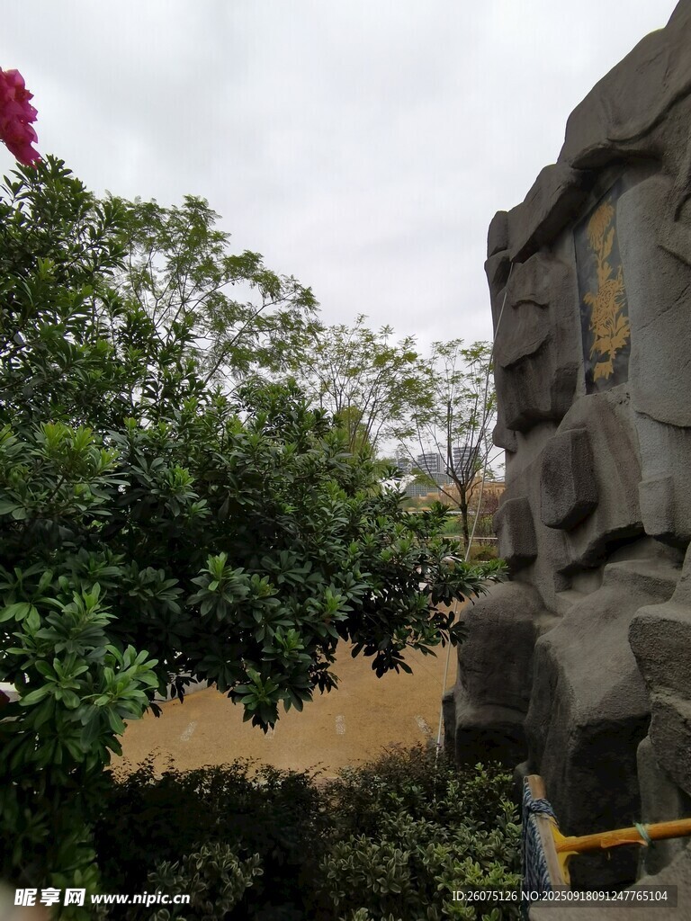 古老石雕旁的繁茂綠植