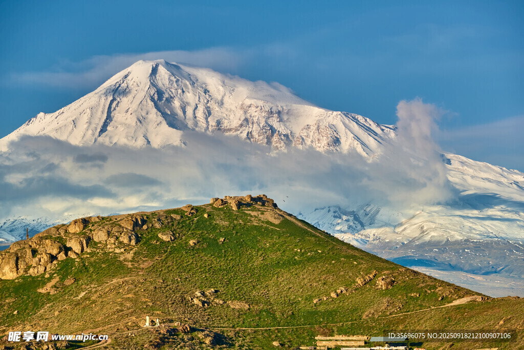 壯麗雪山下的綠色山丘