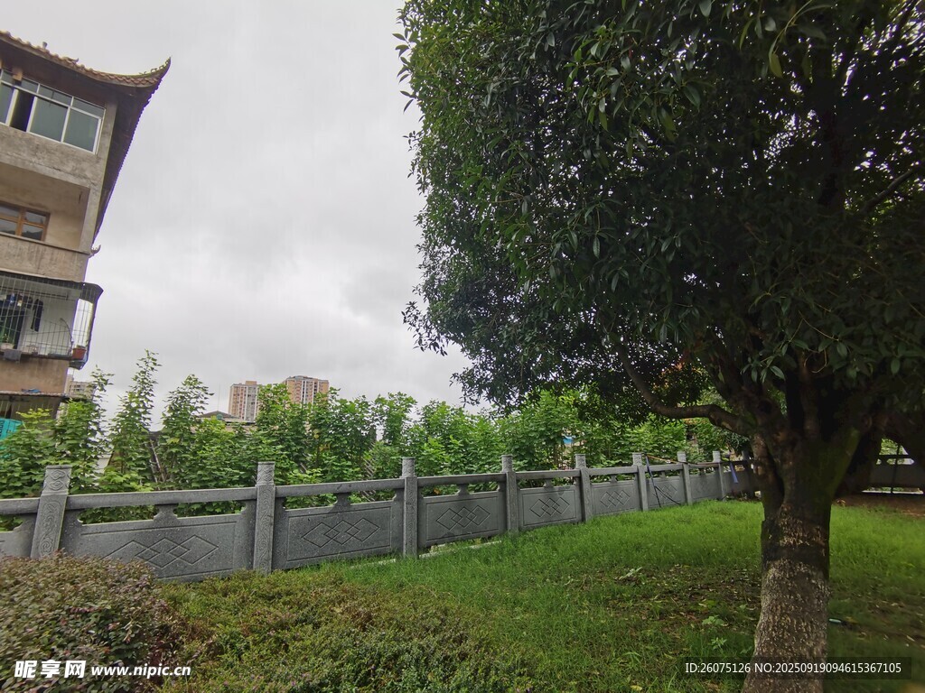 中式建筑旁的綠樹與圍欄