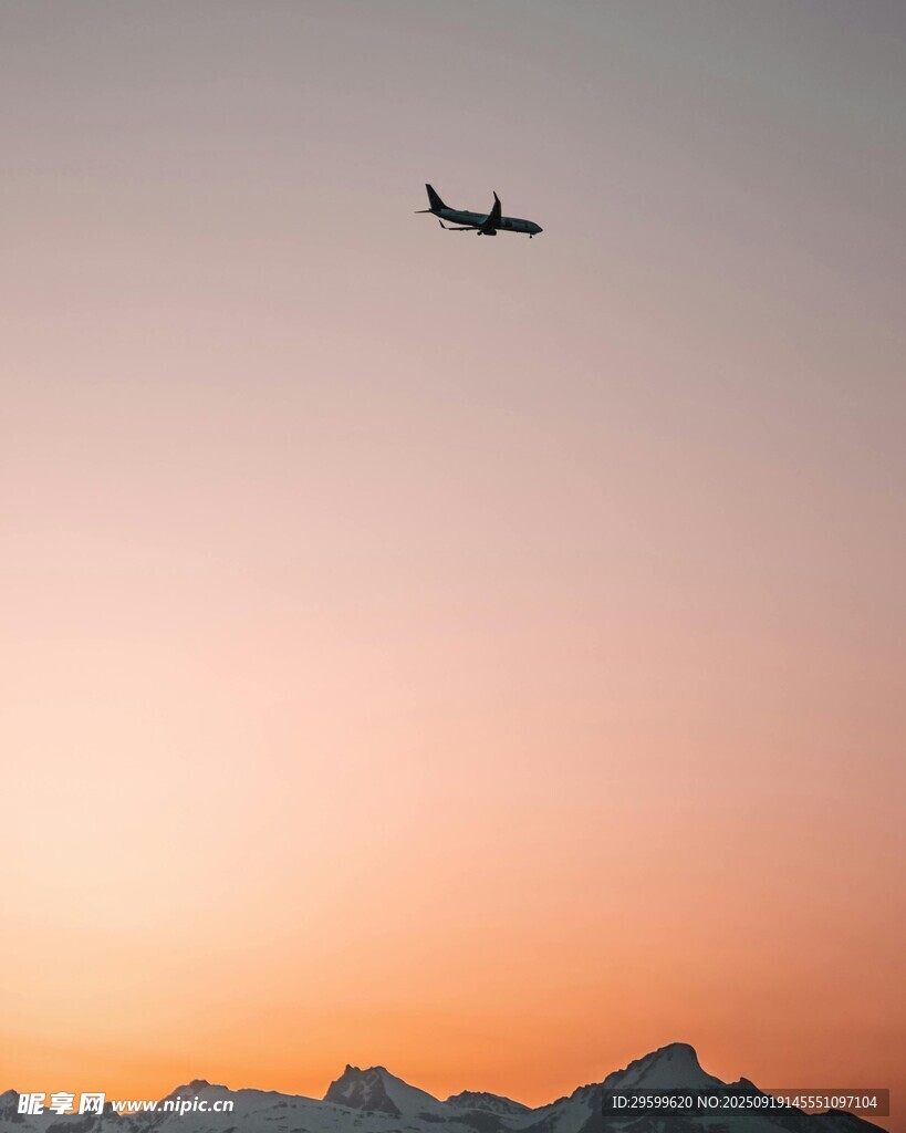 夕陽下飛機飛越山巒