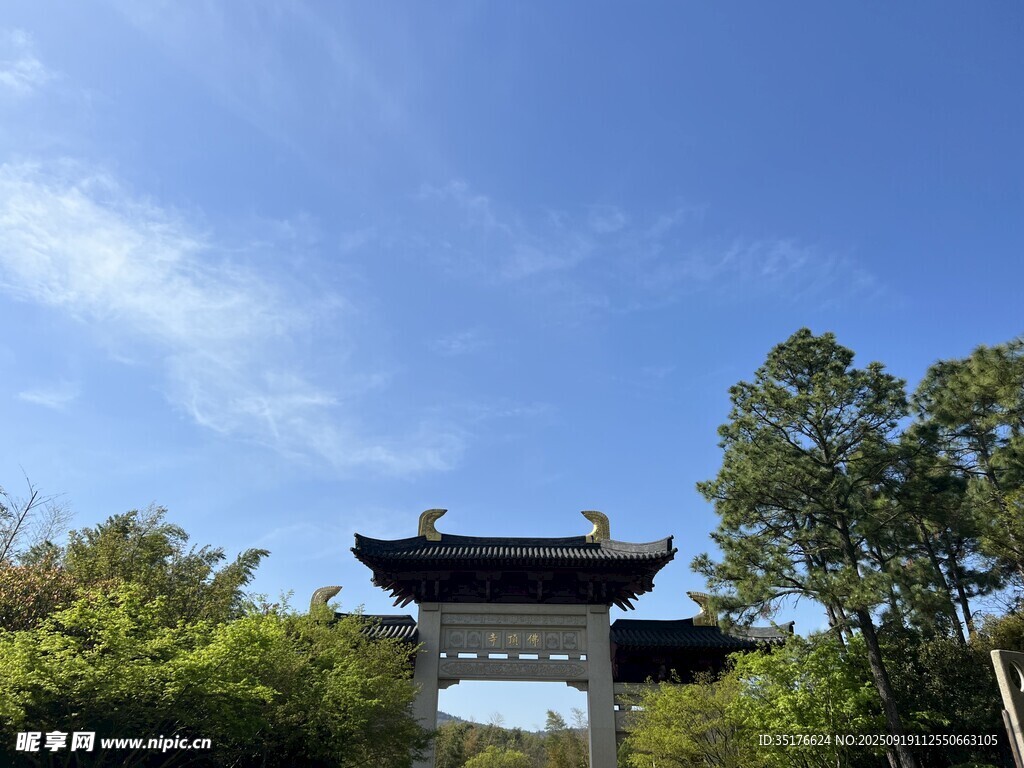中式門樓映于藍(lán)天綠樹間