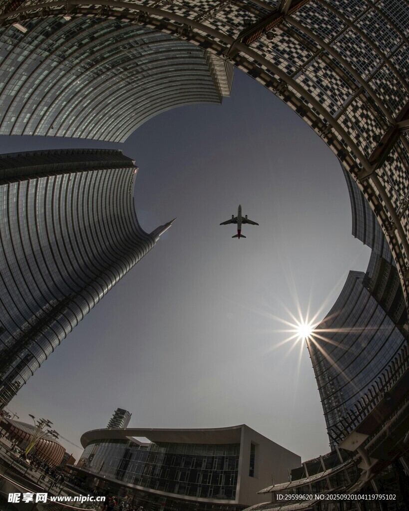 城市高樓間飛機(jī)翱翔景象