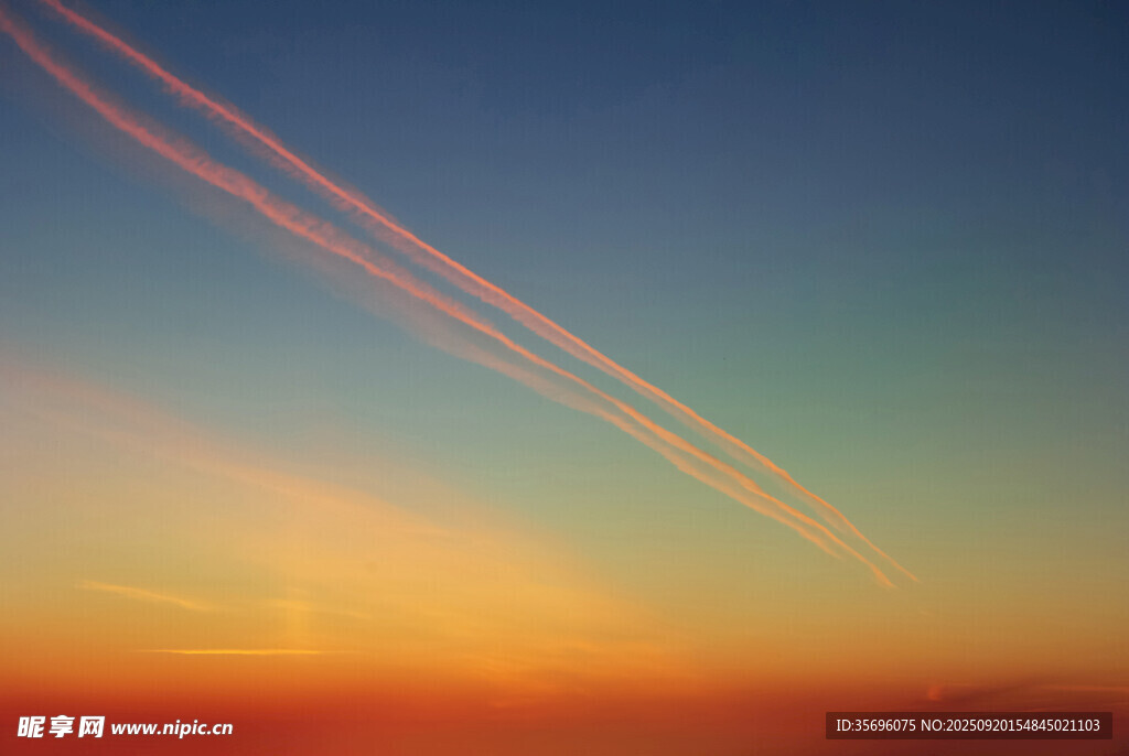 夕陽下的空中飛機尾跡