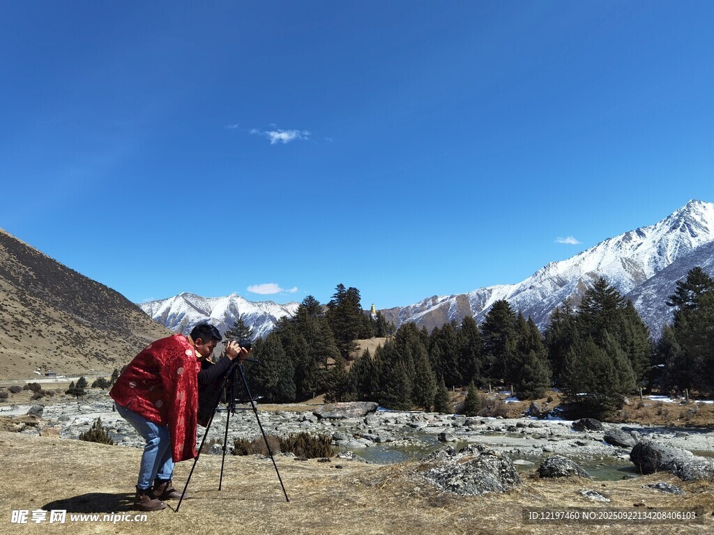 戶外攝影師雪山前專注拍攝