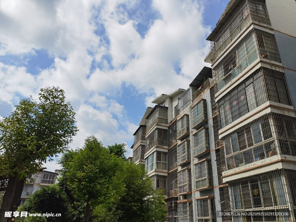 多層住宅旁綠樹(shù)與藍(lán)天