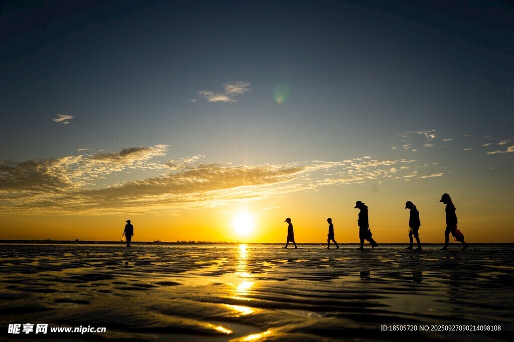 海邊夕陽下的人群剪影