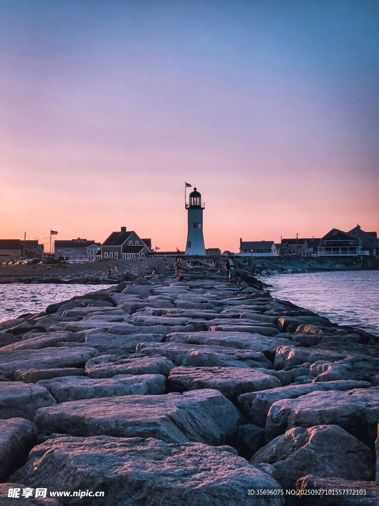 黃昏海邊的燈塔與石堤