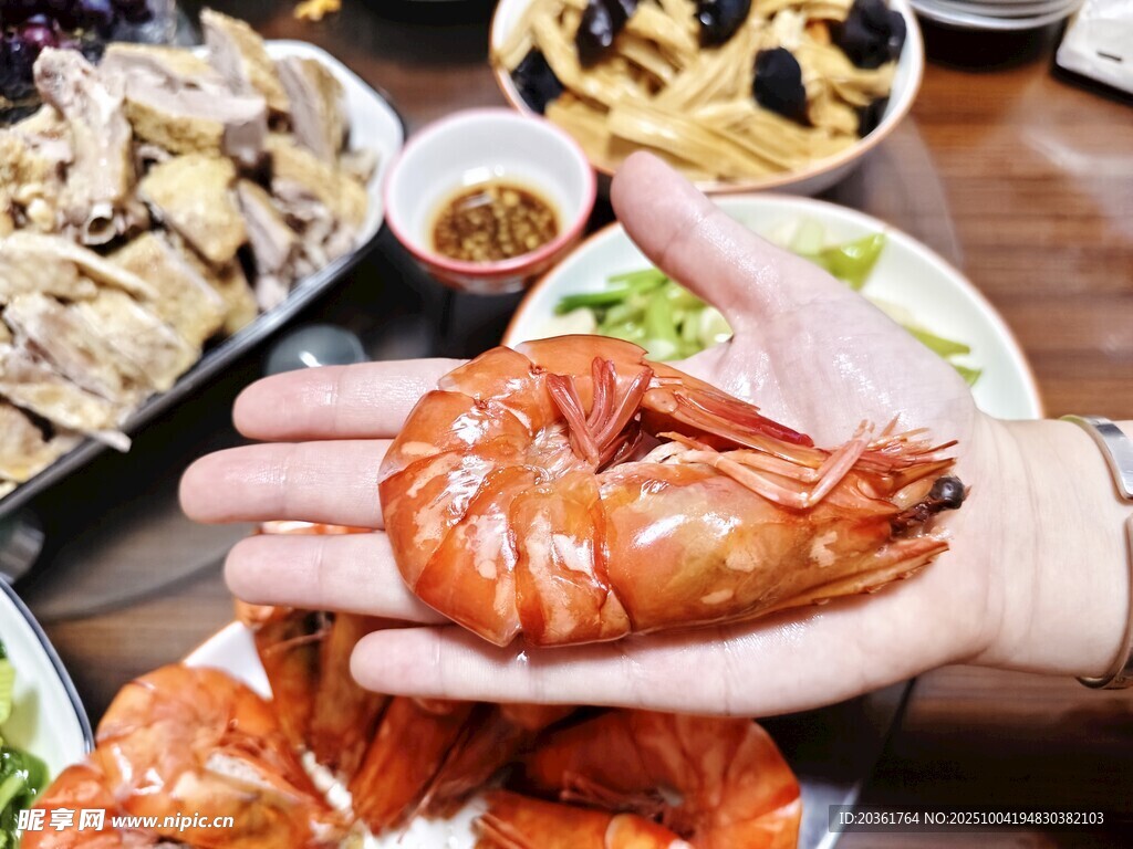 手捧美味大蝦的豐盛餐食