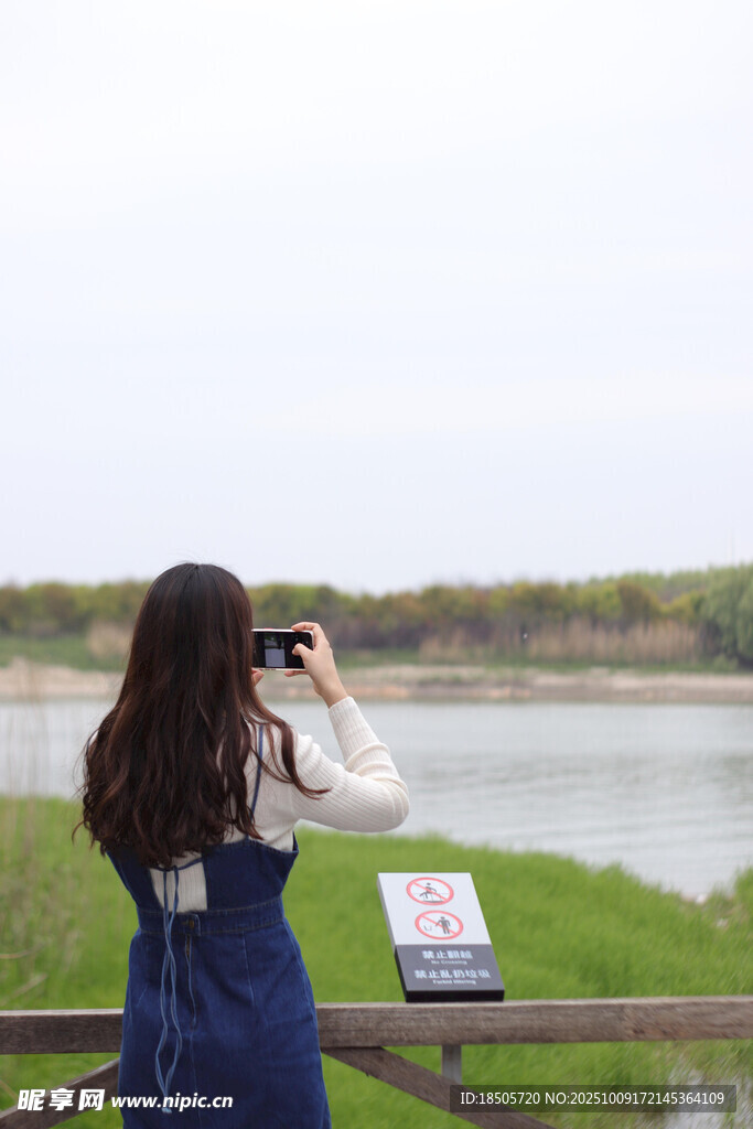 女孩河畔專注拍照瞬間
