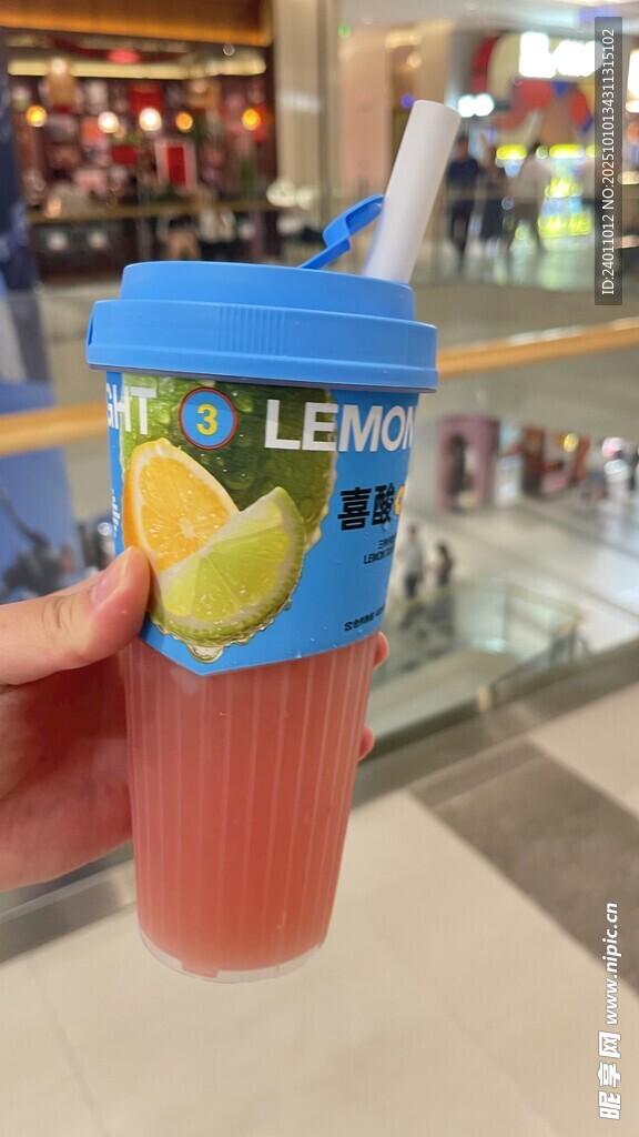 手持藍(lán)色杯裝檸檬冰飲