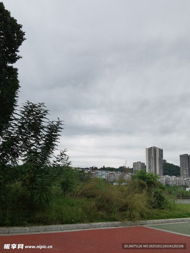 城市旁的綠樹(shù)與紅色跑道