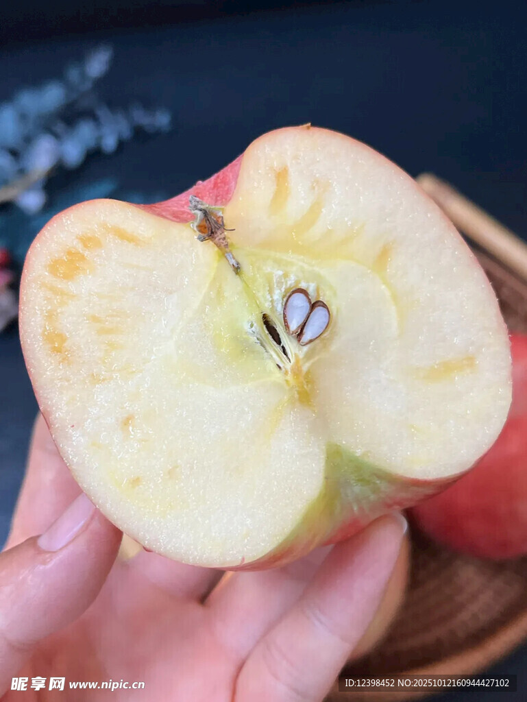 手捧切開帶蟲的紅蘋果