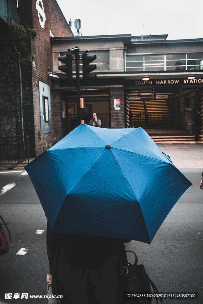 雨中藍(lán)傘下的城市街景
