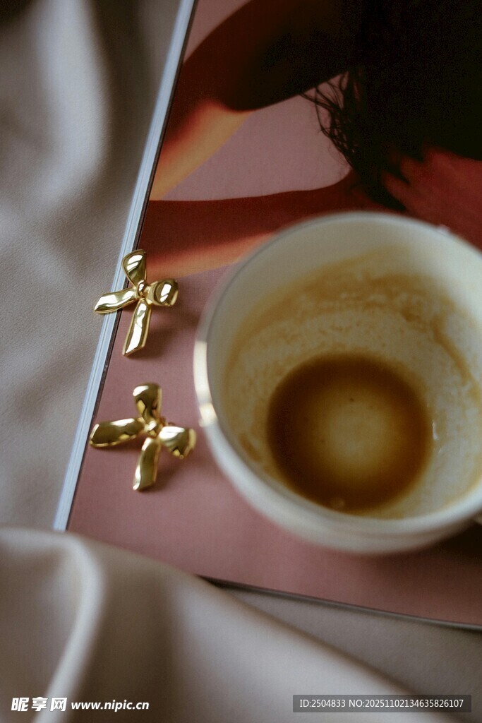 咖啡杯旁的金色小擺件