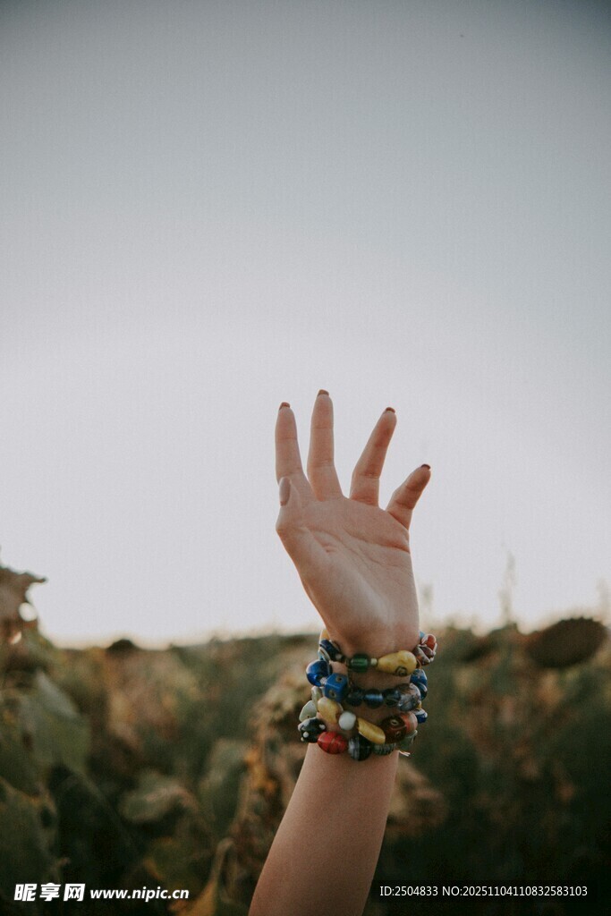 戴多彩手鏈的手伸向天空