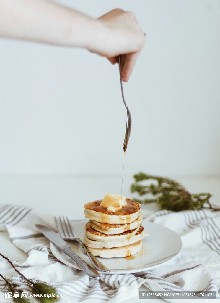 手舀糖漿淋在美味松餅上
