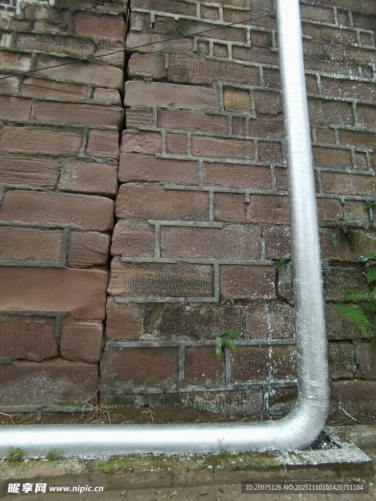 老舊磚墻旁的金屬管道