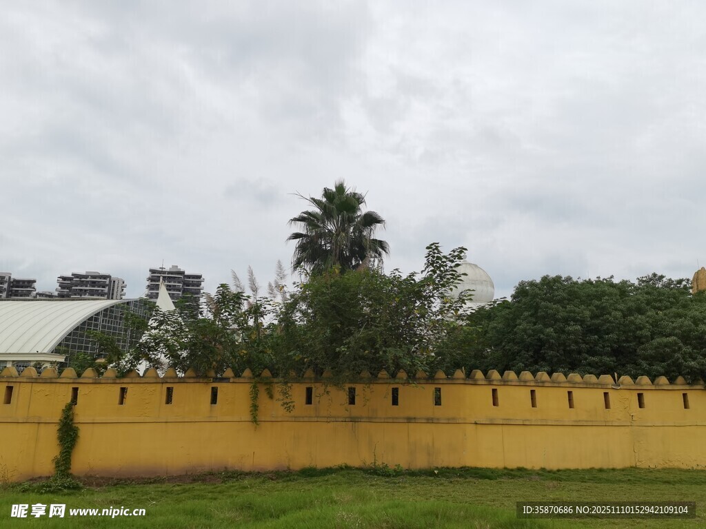 黃色圍墻旁的綠植與建筑