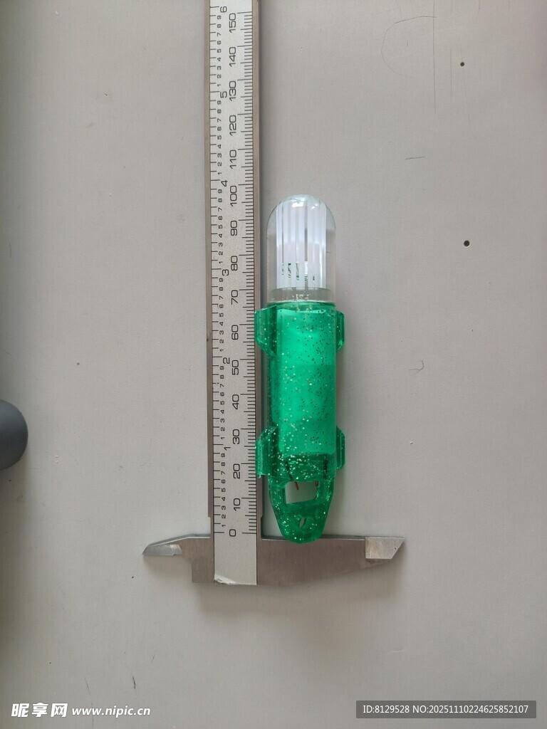 綠色小瓶置于金屬尺旁