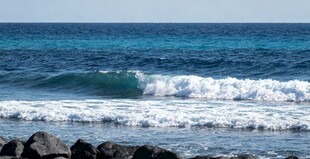 海邊浪花拍打礁石景象