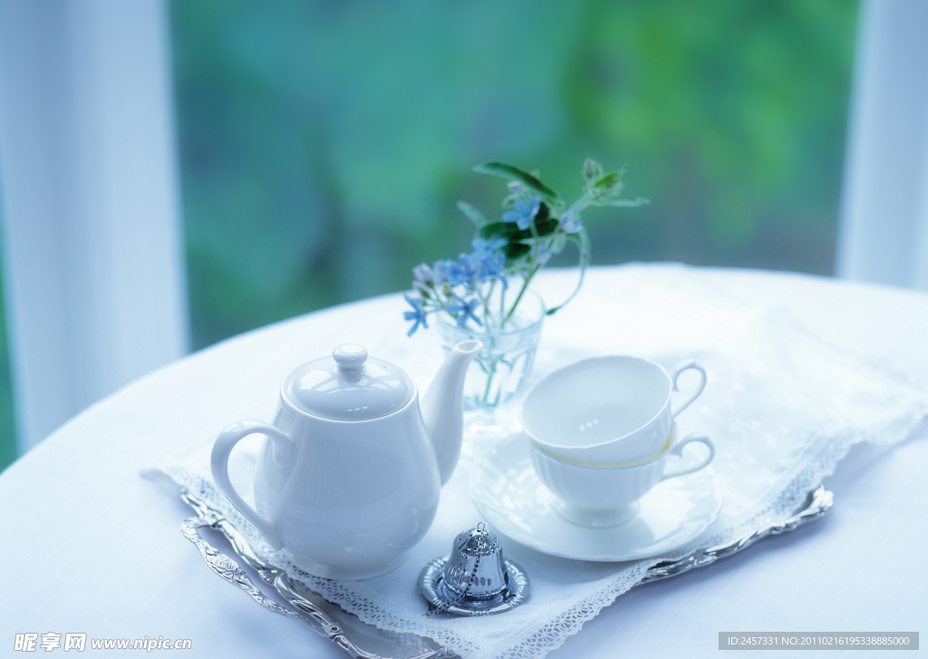 室内圆桌上的茶杯茶壶鲜花