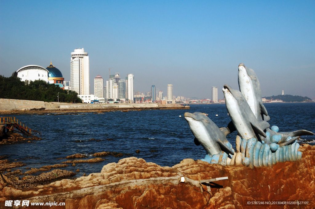 海豚雕塑与海边建筑相