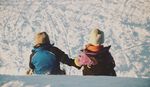 坐在雪地上的小孩背影
