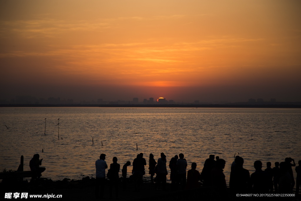 夕阳下海滩人群剪影图片
