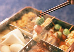 筷子夹起食盒里串起来的麻辣烫
