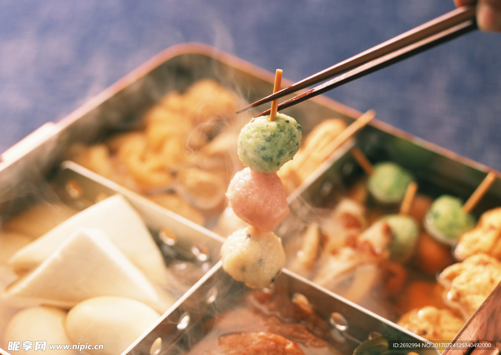 筷子夹起食盒里串起来的麻辣烫