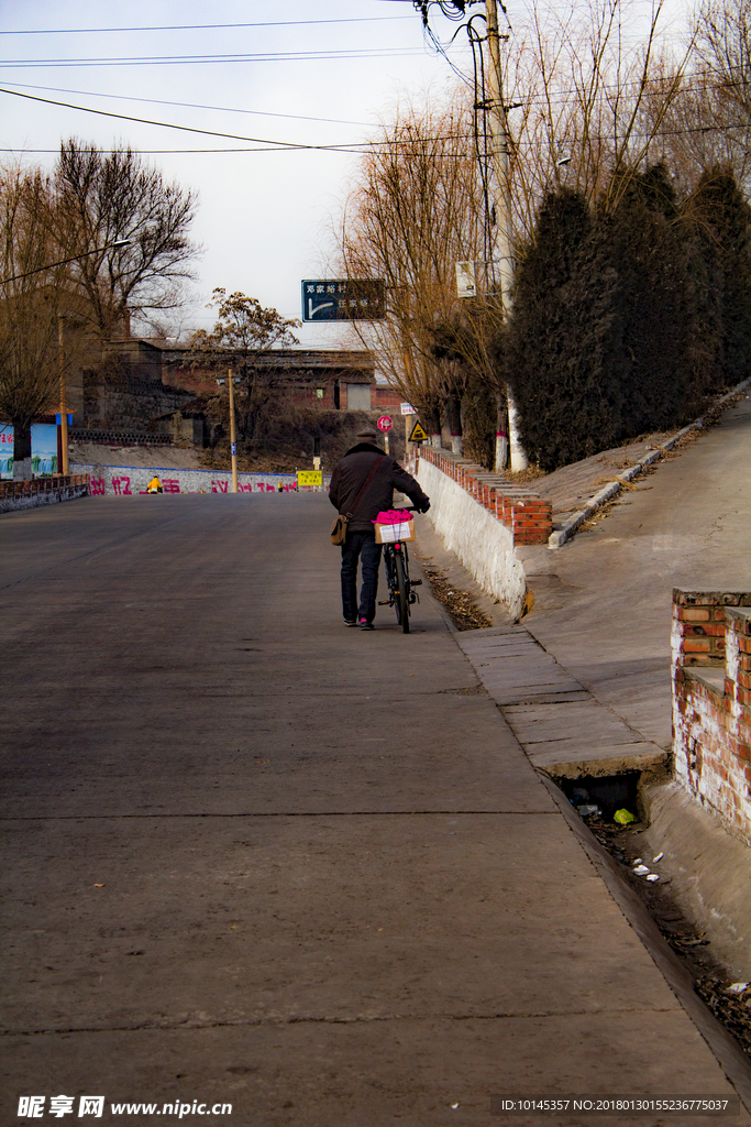 公路上推自行车远去的路人