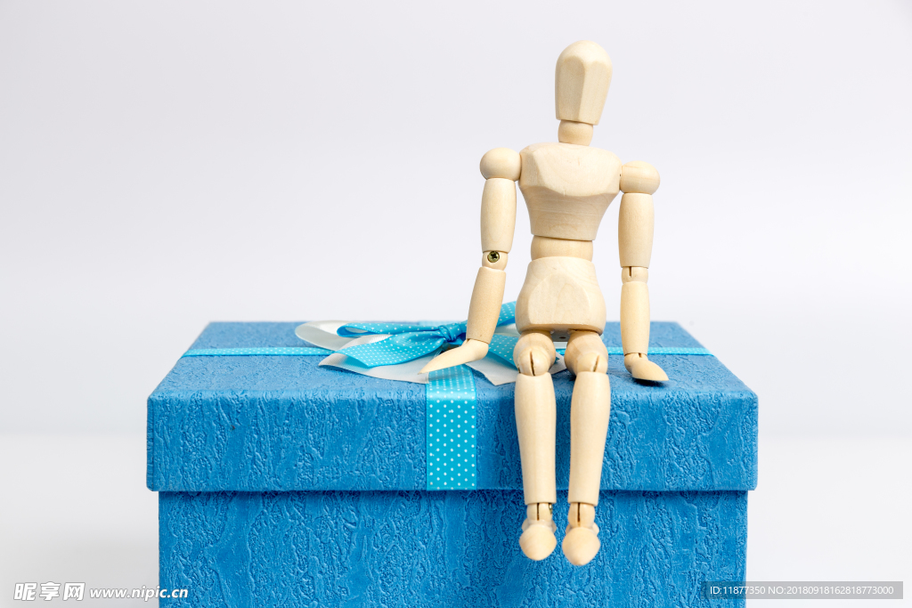 蓝色礼物盒与坐着的人偶