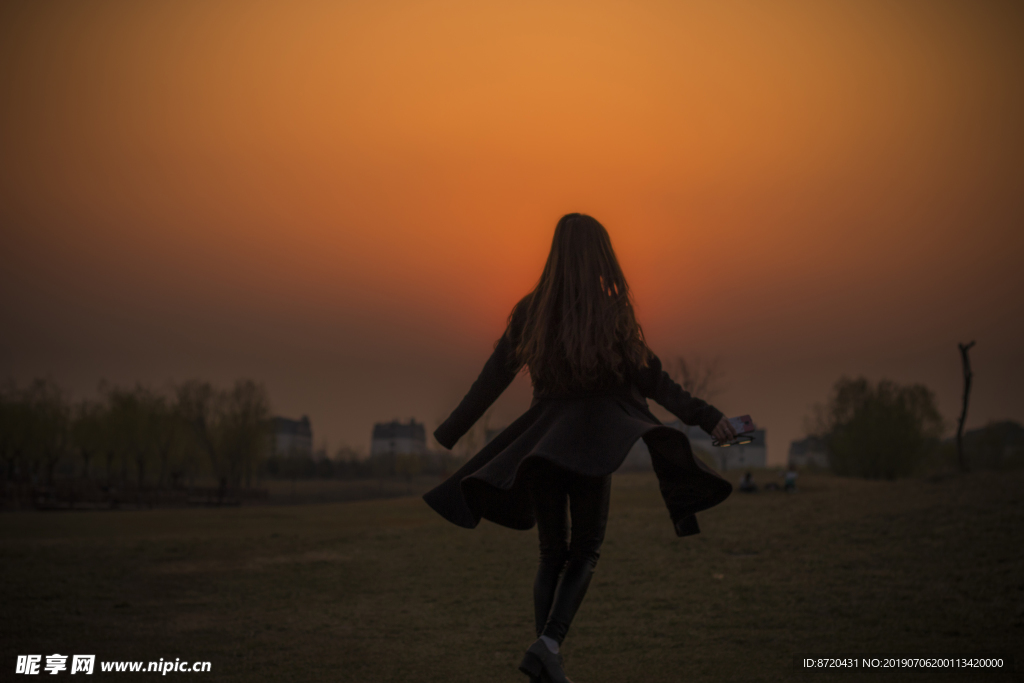 夕阳落日下女孩旋转飞舞的衣摆