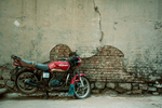 破旧水泥墙边的一辆摩托车