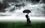 打伞商务人站在打雷下雨的草坪