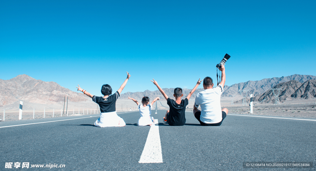 一家四口坐在公路上