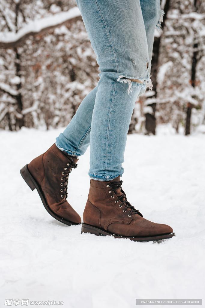踩在雪地上鞋子牛仔裤腿