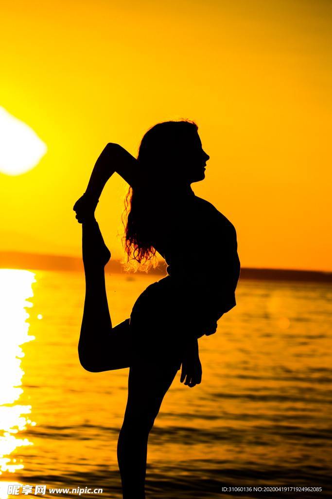 海边夕阳下女性锻炼图